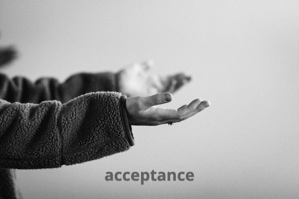Sepia toned photograph with two open hands, palms facing up, with the word "acceptance" below.